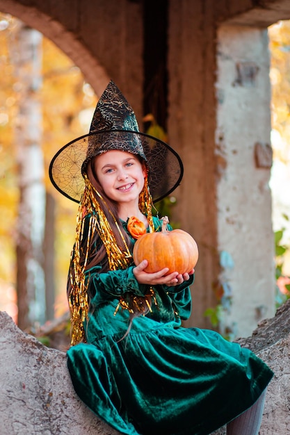 Felice festa di Halloween Strega bella ragazza con zucca nel parco all'aperto