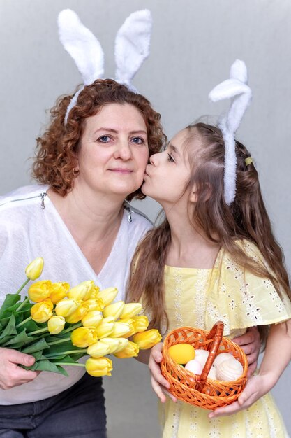 Felice festa una madre e sua figlia festeggiano la Pasqua la bambina indossa orecchie di coniglio