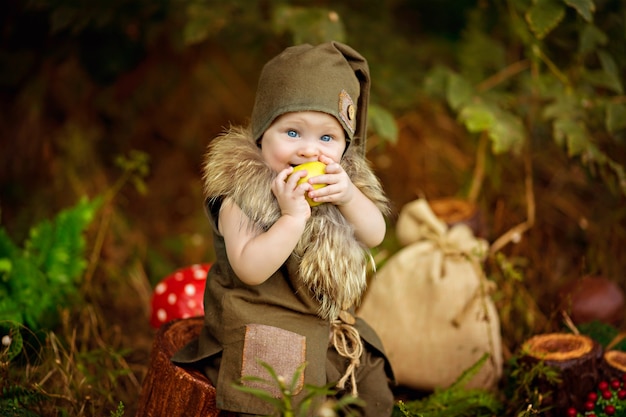 Felice fiaba bambino gnomo ragazzo giocando e camminando nella foresta mangiando mele