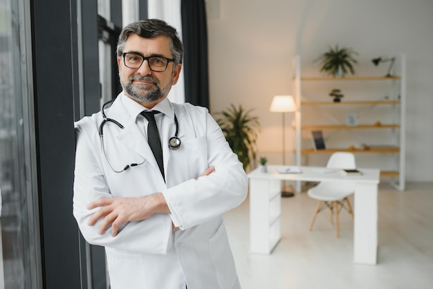 Felice fiducioso vecchio medico professionista in piedi Sorridente medico adulto senior affidabile terapista di successo che indossa camice bianco e ritratto stetoscopio