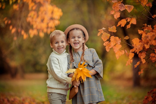 Felice fratello e sorella in una passeggiata nel parco in autunno