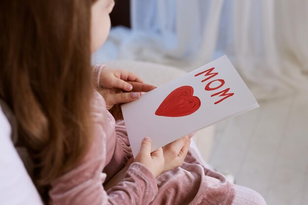 Felice Giornata delle Madri Bambina figlia congratula sua madre e le dà la cartolina