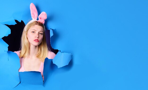 Felice giorno di pasqua ragazza bionda in orecchie da coniglio coniglio donna sullo shopping pasquale e vendita stagionale al dettaglio