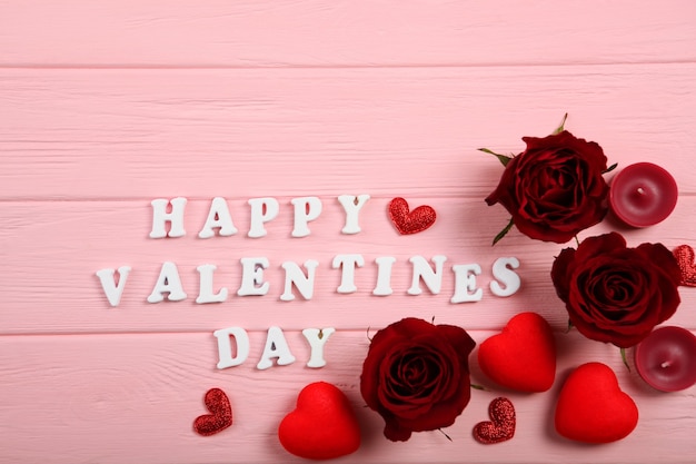 Felice giorno di San Valentino testo con rose rosse e cuori su sfondo rosa