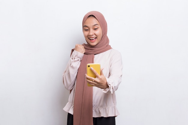 Felice giovane asiatica bella donna musulmana utilizzando il telefono cellulare isolato su sfondo bianco