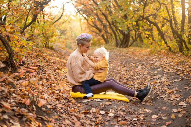 Felice giovane bella madre con il suo piccolo figlio nel parco