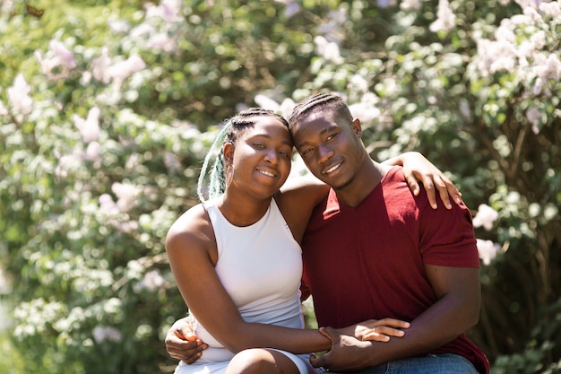felice giovane coppia africana di persone in una passeggiata in un parco fiorito d'estate