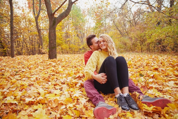 Felice giovane coppia all'aperto in una bella giornata autunnale nella foresta