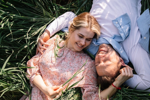 Felice giovane coppia che sogna insieme nel parco sull'erba, i giovani agricoltori si rallegrano della raccolta