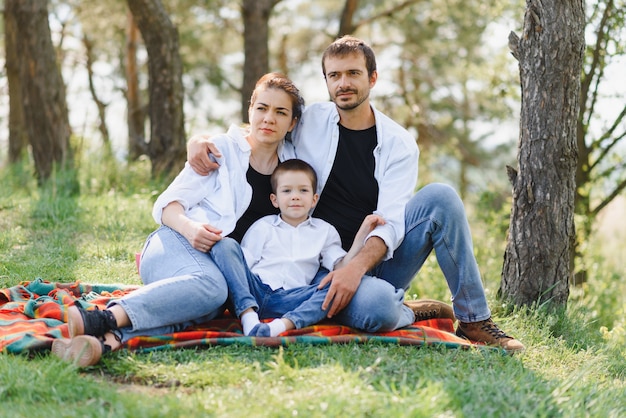 Felice giovane coppia con i loro figli si divertono al bellissimo parco all'aperto nella natura