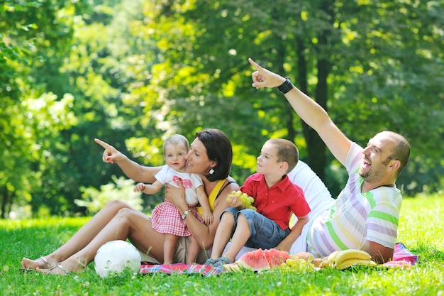 Felice giovane coppia con i loro figli si divertono al bellissimo parco all'aperto nella natura