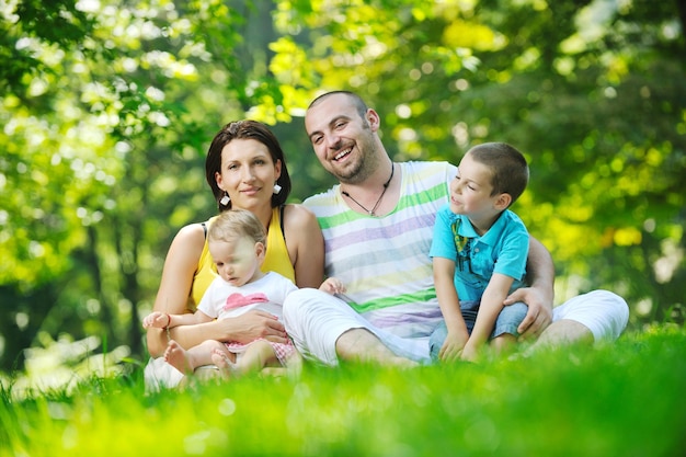 Felice giovane coppia con i loro figli si divertono al bellissimo parco all'aperto nella natura