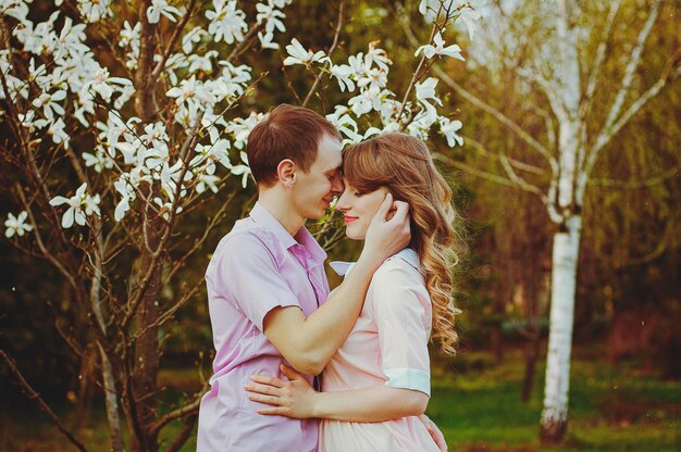 Felice giovane coppia, famiglia che cammina nel parco di primavera. Tramonto. Aspetto familiare. Stile di vita. Data. Amore