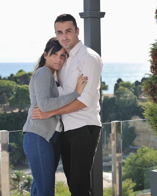 felice giovane coppia innamorata ha romanticismo rilassarsi sul balcone all'aperto con l'oceano e il cielo blu sullo sfondo