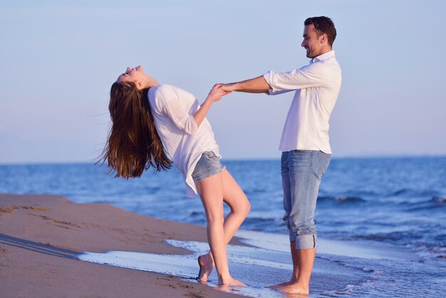 felice giovane coppia romantica innamorata divertirsi sulla bellissima spiaggia in una bella giornata estiva