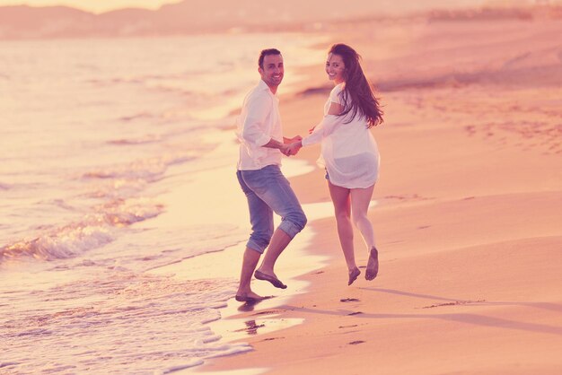 felice giovane coppia romantica innamorata divertirsi sulla bellissima spiaggia in una bella giornata estiva