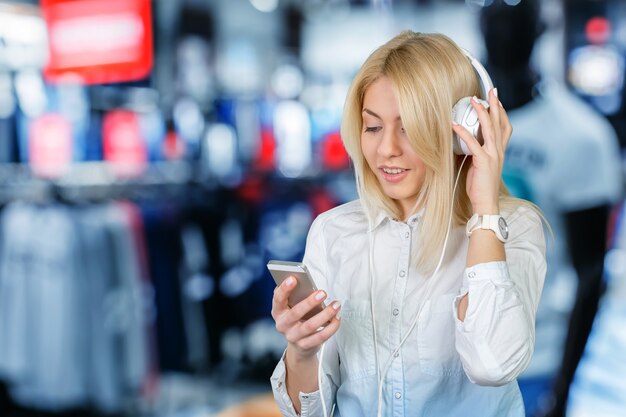 Felice giovane donna bionda che ascolta la musica