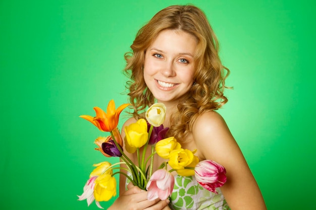 Felice giovane donna che abbraccia un mazzo di tulipani