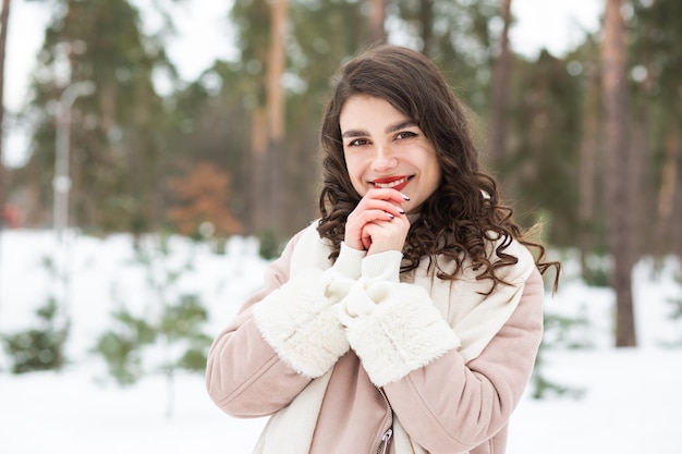 Felice giovane donna che cammina al parco invernale. Spazio per il testo