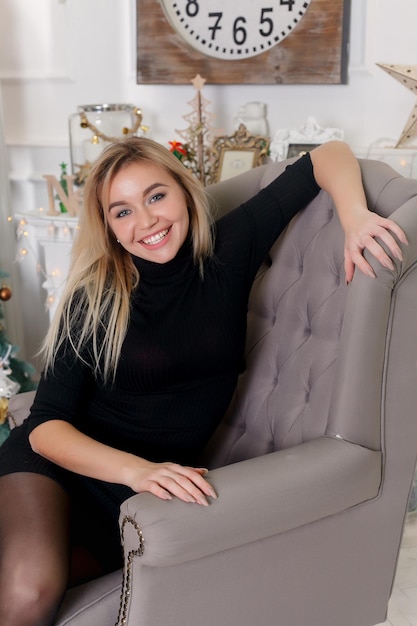 Felice giovane donna che decora l'albero di Natale a casa