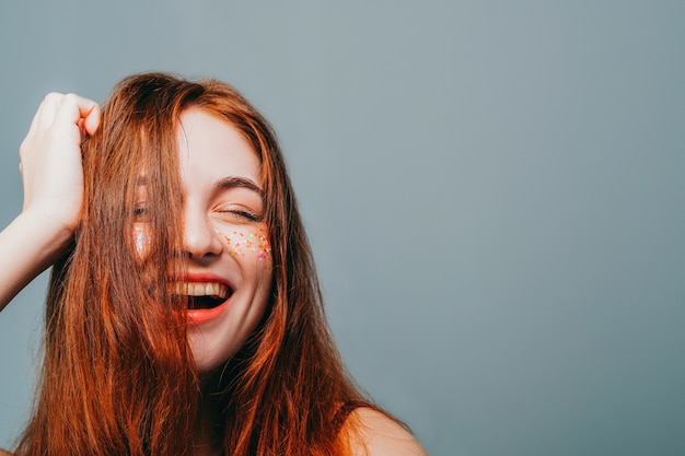 Felice giovane donna. Divertimento e libertà. Femmina rossa con sorriso a trentadue denti e scintillii sulle guance