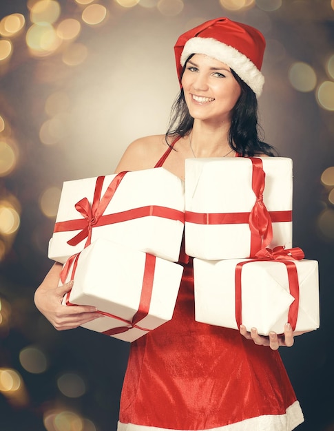 Felice giovane donna in costume di babbo natale con tanto shopping natalizio bellissimo effetto bokeh f