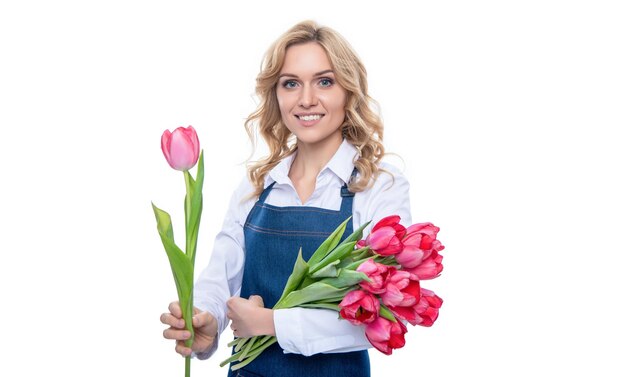 Felice giovane donna in grembiule con fiori di tulipano di primavera isolati su sfondo bianco