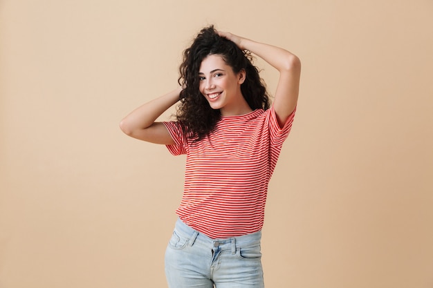 Felice giovane donna isolata sul muro beige