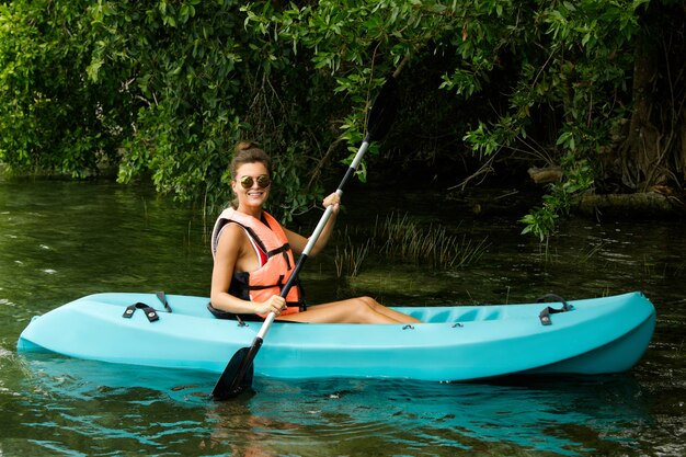 Felice giovane donna kayak sul lago