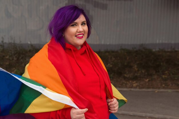 felice giovane donna lesbica che tiene bandiera lgbtq pride