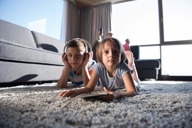 Felice giovane famiglia che gioca insieme a casa.bambini che utilizzano tablet sul pavimento