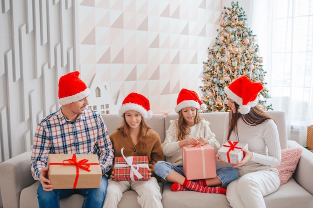 Felice giovane famiglia con bambini che tengono i regali di Natale