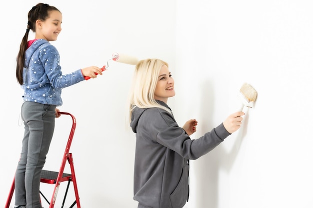 Felice giovane famiglia con la piccola figlia che dipinge il muro.