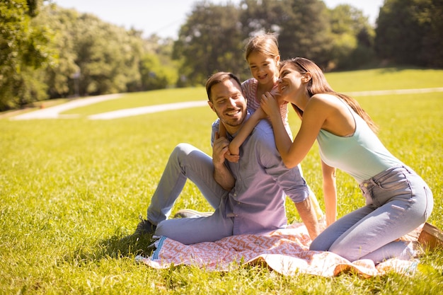 Felice giovane famiglia con una piccola figlia carina che si diverte nel parco in una giornata di sole