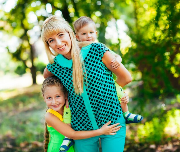 Felice giovane famiglia, madre e bambini insieme divertendosi all'aperto sulla natura