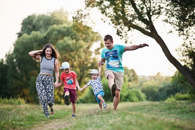 Felice giovane famiglia: madre, padre, figlio di due bambini sulla natura divertendosi.