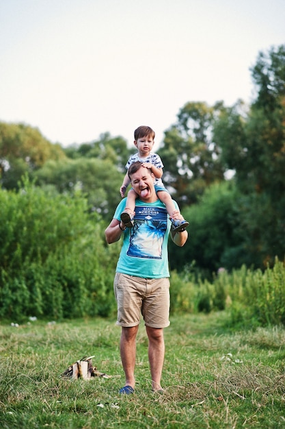 Felice giovane famiglia: padre con figlio sulla natura divertendosi.