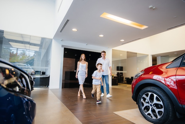 Felice giovane famiglia sceglie e acquista una nuova auto presso una concessionaria di automobili