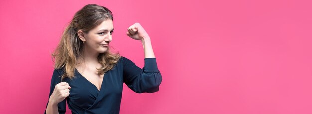 Felice giovane femmina caucasica alza un pugno chiuso per la gioia Successo e felicità