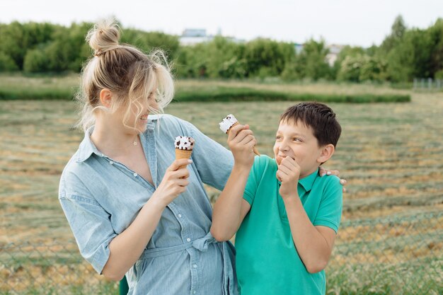 Felice giovane mamma single con suo figlio adolescente che si diverte in vacanza. Famiglia che mangia il gelato e ride