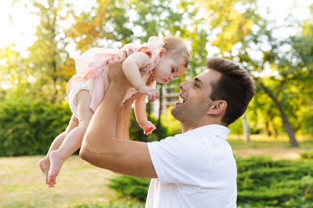 Felice giovane padre che gioca con la sua piccola figlia