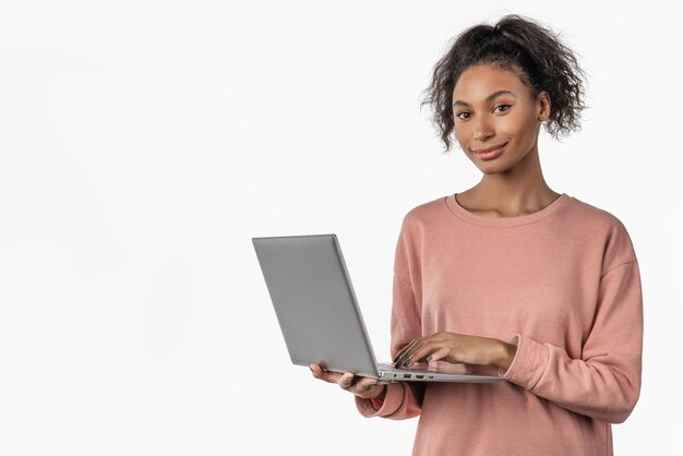 Felice giovane ragazza africana utilizzando il computer portatile isolato su sfondo bianco