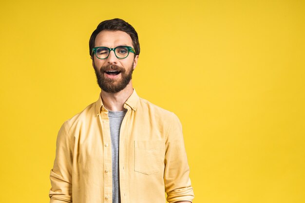 Felice giovane. Ritratto di bel giovane uomo barbuto in casual sorridente mentre isolato su sfondo giallo.