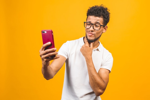 felice giovane uomo afroamericano prendendo un selfie per telefono.