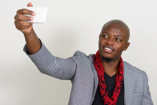 Felice giovane uomo d'affari africano calvo prendendo selfie