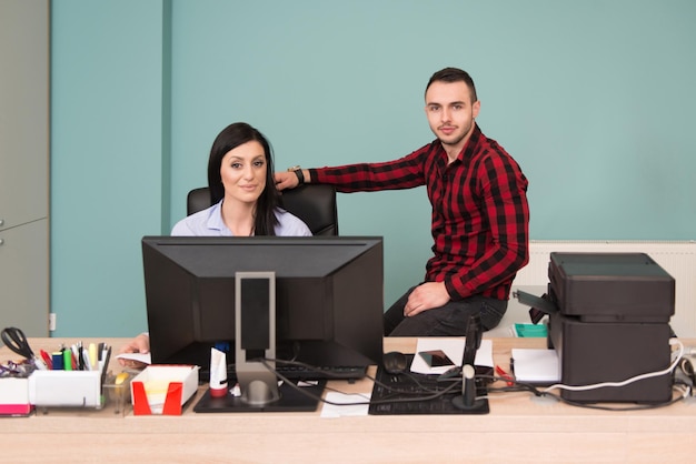 Felice giovane uomo d'affari e donna lavorare in ufficio moderno sul computer