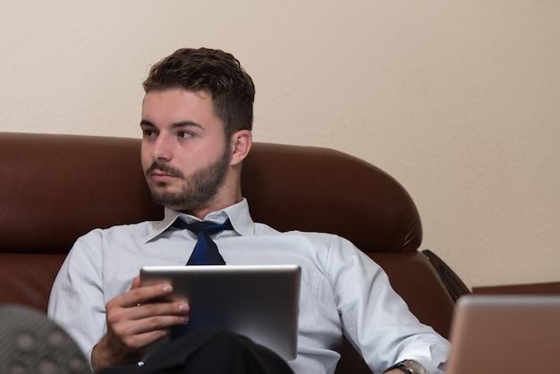 Felice giovane uomo d'affari lavorare in ufficio moderno sul computer