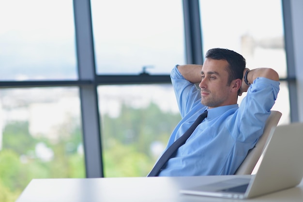 felice giovane uomo d'affari lavorare in un ufficio moderno sul computer