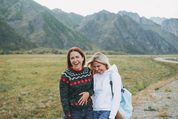 Felice giovani donne viaggiatori su strada contro il bellissimo paesaggio di montagna