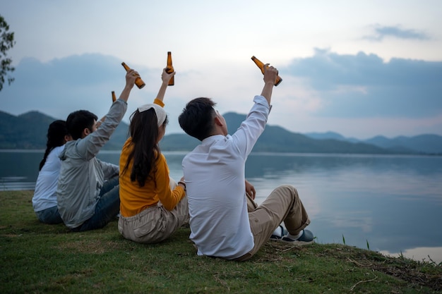 Felice gruppo di amici che trascorrono del tempo facendo un picnic in campeggio e bevendo birra